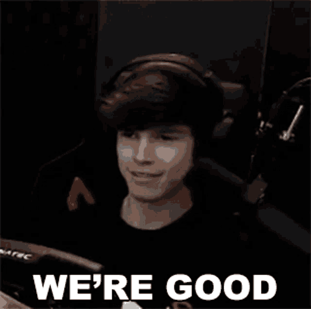 a young man wearing headphones is sitting in a chair with the words `` we 're good '' written on it .
