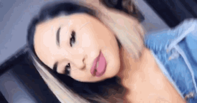a woman is taking a selfie with her tongue sticking out .