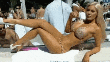 a woman in a bikini is laying on a white towel that says ucl