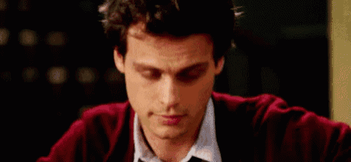 a close up of a man 's face with a red sweater on .