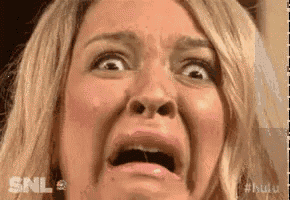 a woman is making a funny face with her mouth open and her eyes closed .