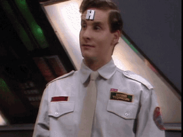 a man with the letter h on his forehead is wearing a white uniform
