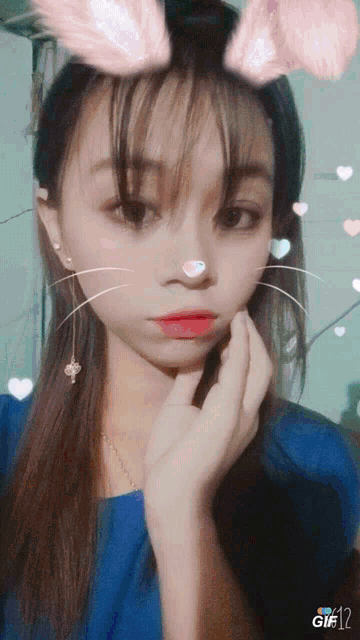 a girl with bunny ears on her face and the number 12 on the bottom left