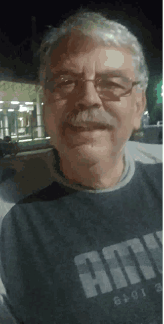 a man with glasses and a mustache wears a shirt that says army