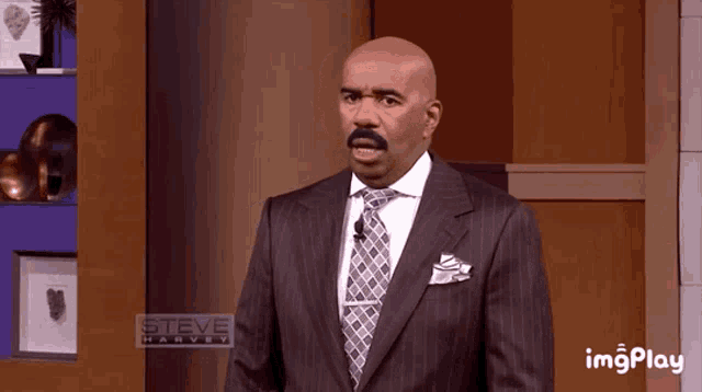 a bald man in a suit and tie is on steve harvey
