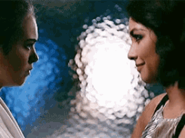 two women are looking at each other in a dark room