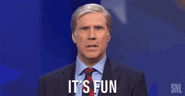 a man in a suit and tie is saying `` it 's fun '' while standing in front of a blue background .