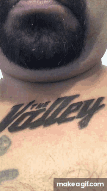 a man with a beard has a tattoo on his chest that says the valley