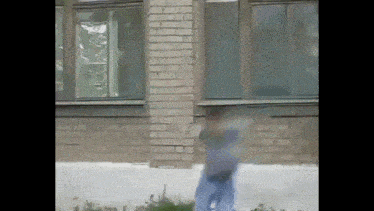 a person is standing in front of a brick building