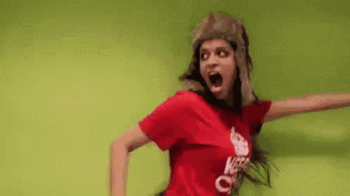 a woman wearing a fur hat and a red t-shirt is dancing .