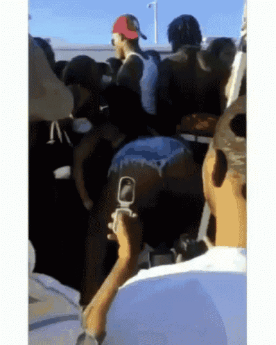 a man is taking a picture of a woman dancing in a crowd .