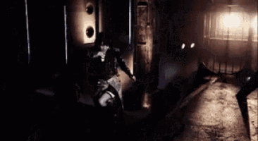 a woman in a wheelchair is sitting in a dark room with a man standing behind her .