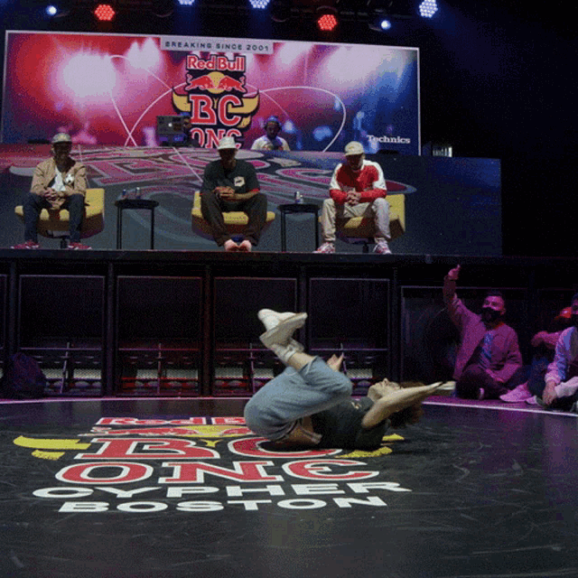 a man is laying on the floor in front of a sign that says red bull