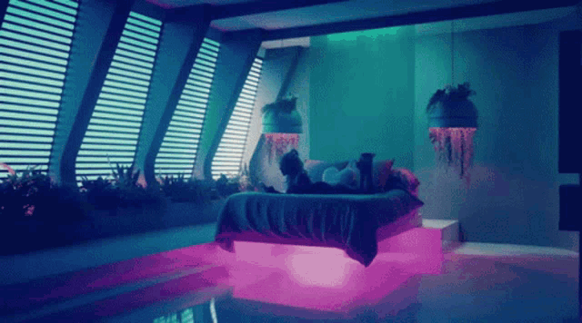 a woman laying on a bed in a room with purple lights