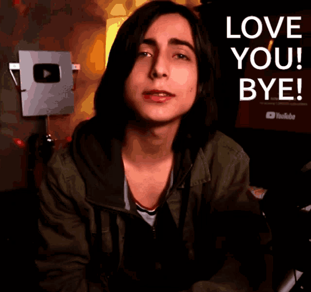 a young man waving his hand in front of a sign that says " love you bye "