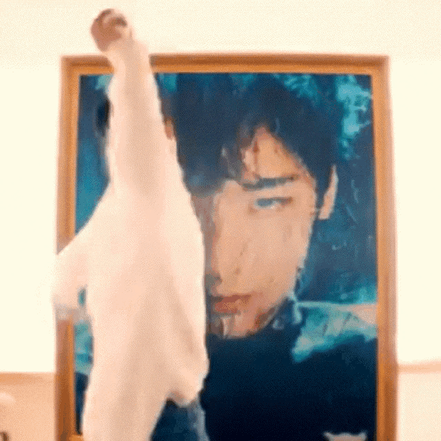 a person is standing in front of a picture of a man .