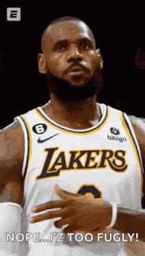 a basketball player with a beard is wearing a lakers jersey and looking at the camera .