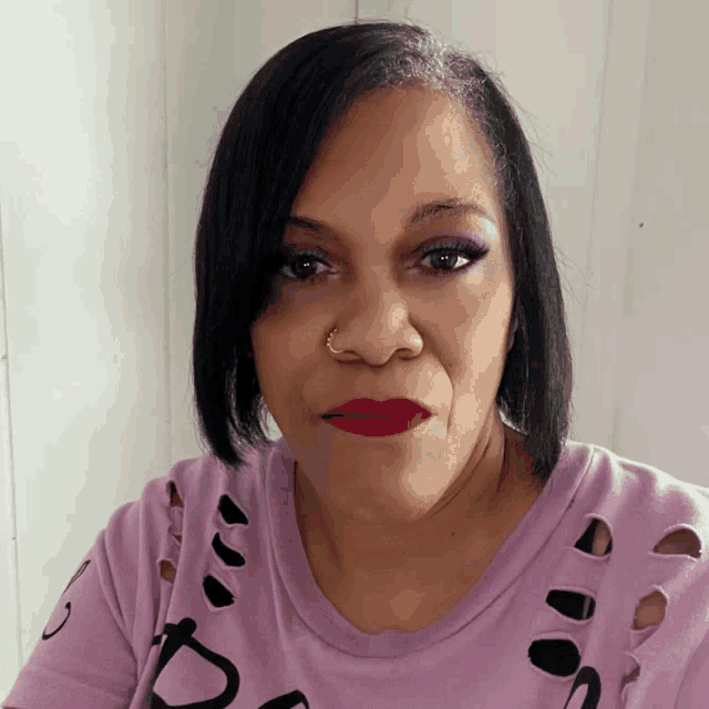 a woman is wearing a purple shirt with holes in it