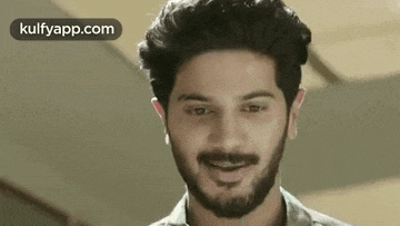 a man with a beard and braces is smiling .
