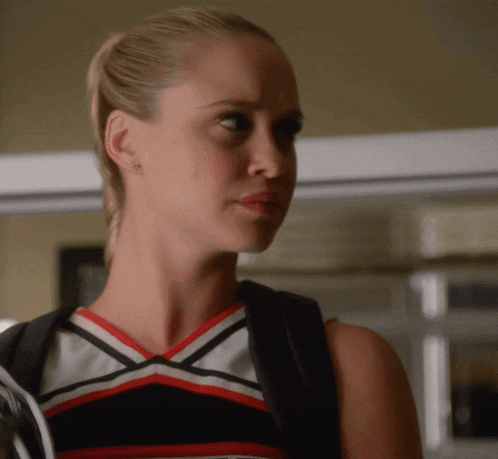 a cheerleader wearing a black white and red uniform looks to the side