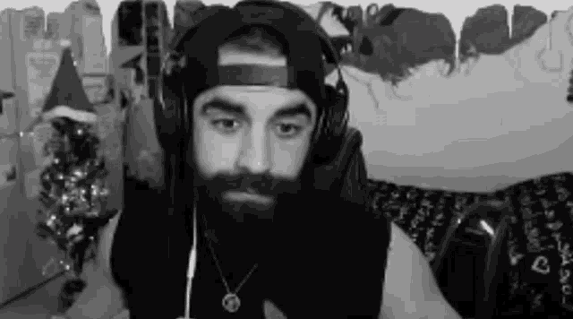 a man with a beard wearing headphones and a santa hat .