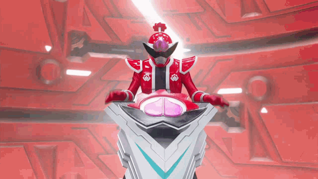 a red robot is sitting on a podium with a light coming out of it