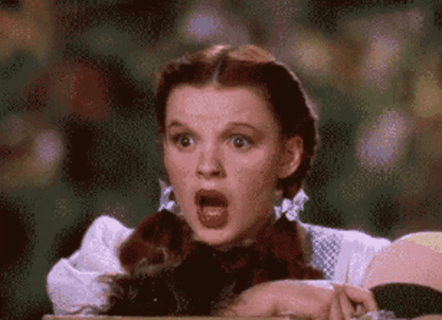 a woman with a surprised look on her face is holding a stick in her hand
