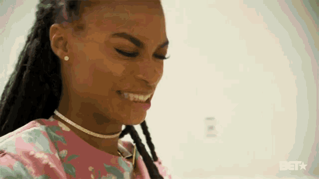 a woman with dreadlocks is smiling and wearing a choker .