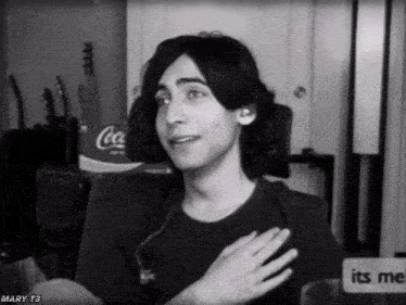 a black and white photo of a man with a coca cola bottle in the background