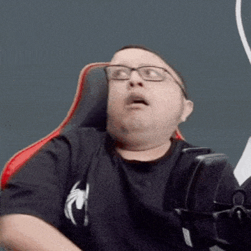 a man wearing glasses and a black shirt is sitting in a chair