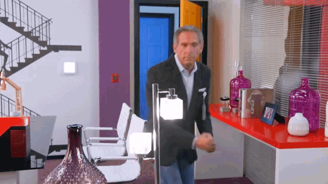 a man in a suit is standing in front of a table with a picture of a woman on it