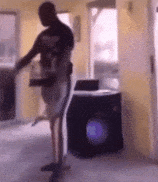 a man is standing in front of a washing machine in a room .