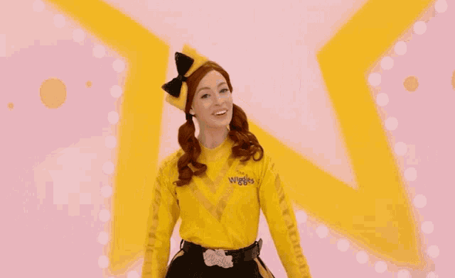 a woman in a yellow wiggle costume is smiling