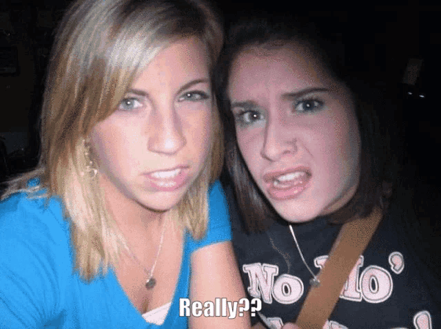 two girls are posing for a picture and one of them is wearing a shirt that says really