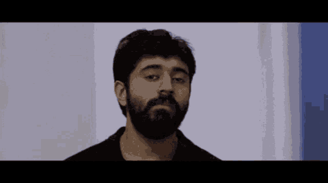 a man with a beard wearing a black shirt