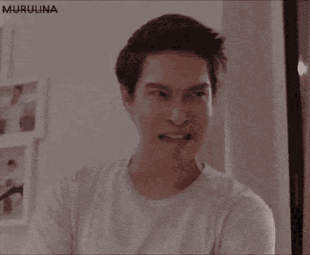 a man in a white shirt is making a funny face with his eyes closed and his mouth open .