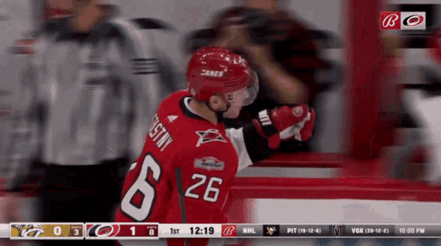a hockey player in a red jersey with the number 26 on it