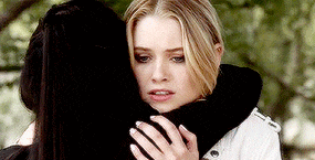 a woman is hugging another woman while standing next to each other .