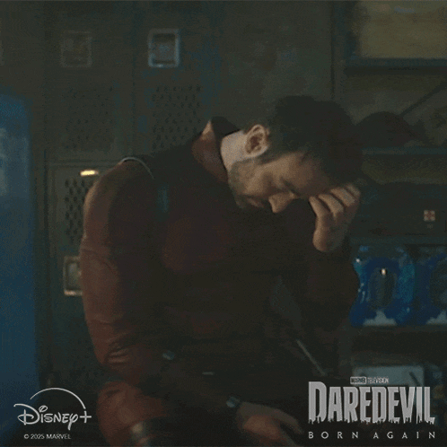 a man is sitting in a dark room with his hand on his forehead in a daredevil born again advertisement .
