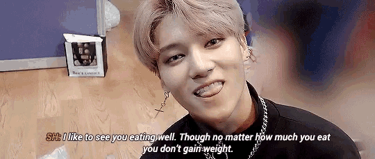 a young man with pink hair is smiling with his tongue hanging out and says i like to see you eating well .