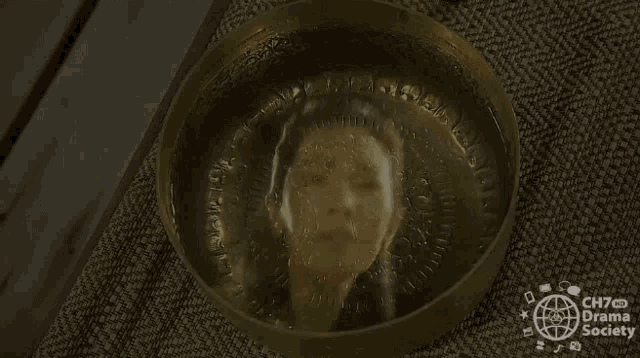 a picture of a woman 's face is in a bowl of water