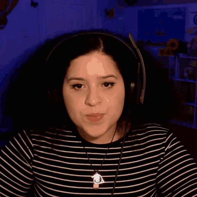 a woman wearing headphones and a necklace with an eye pendant