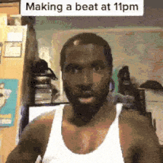 a man wearing a white tank top is making a beat at 11pm