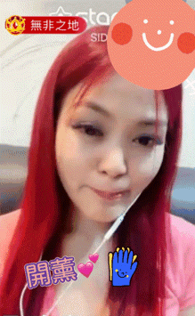 a woman with red hair is wearing a pink shirt and earphones