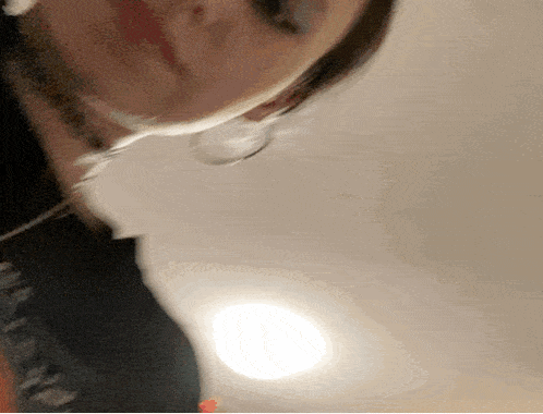 a close up of a person 's face with a light behind her
