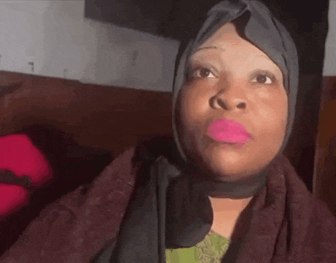 a woman wearing a hijab with pink lipstick on her lips .