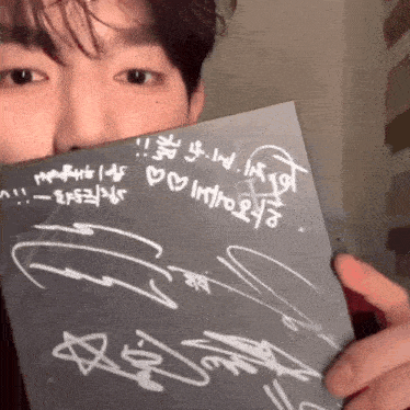 a man is holding a piece of paper that says ' i love you ' on it