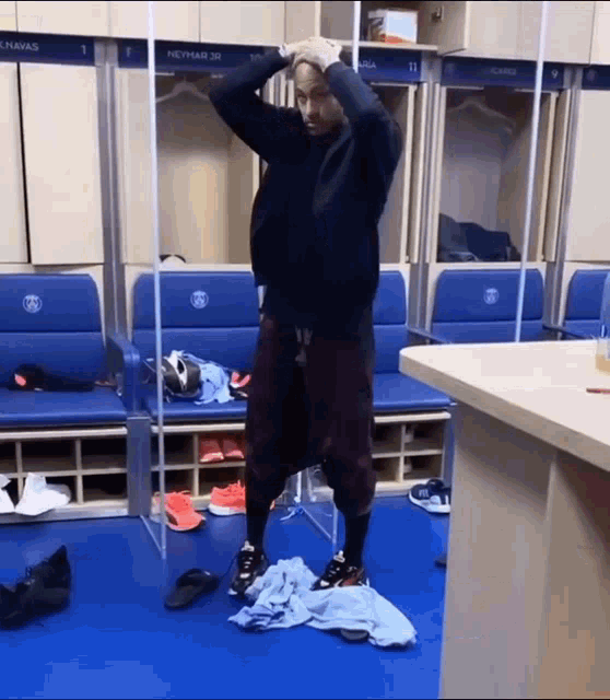 a man is standing in a locker room with the number 1 on the wall