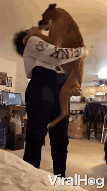 a man is holding a large brown dog in his arms with the words viralhog written below it