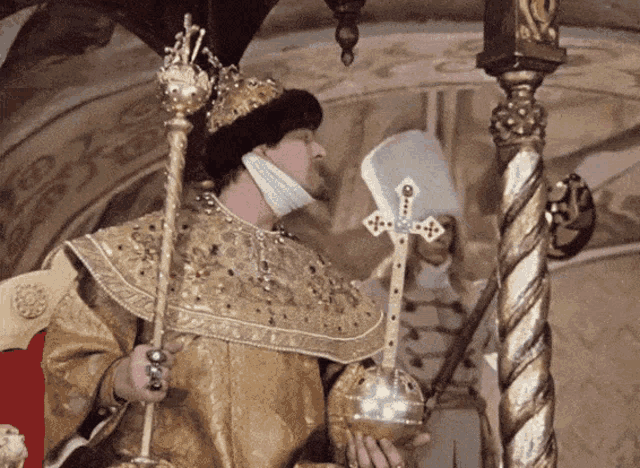 a man with a crown on his head is holding a cane